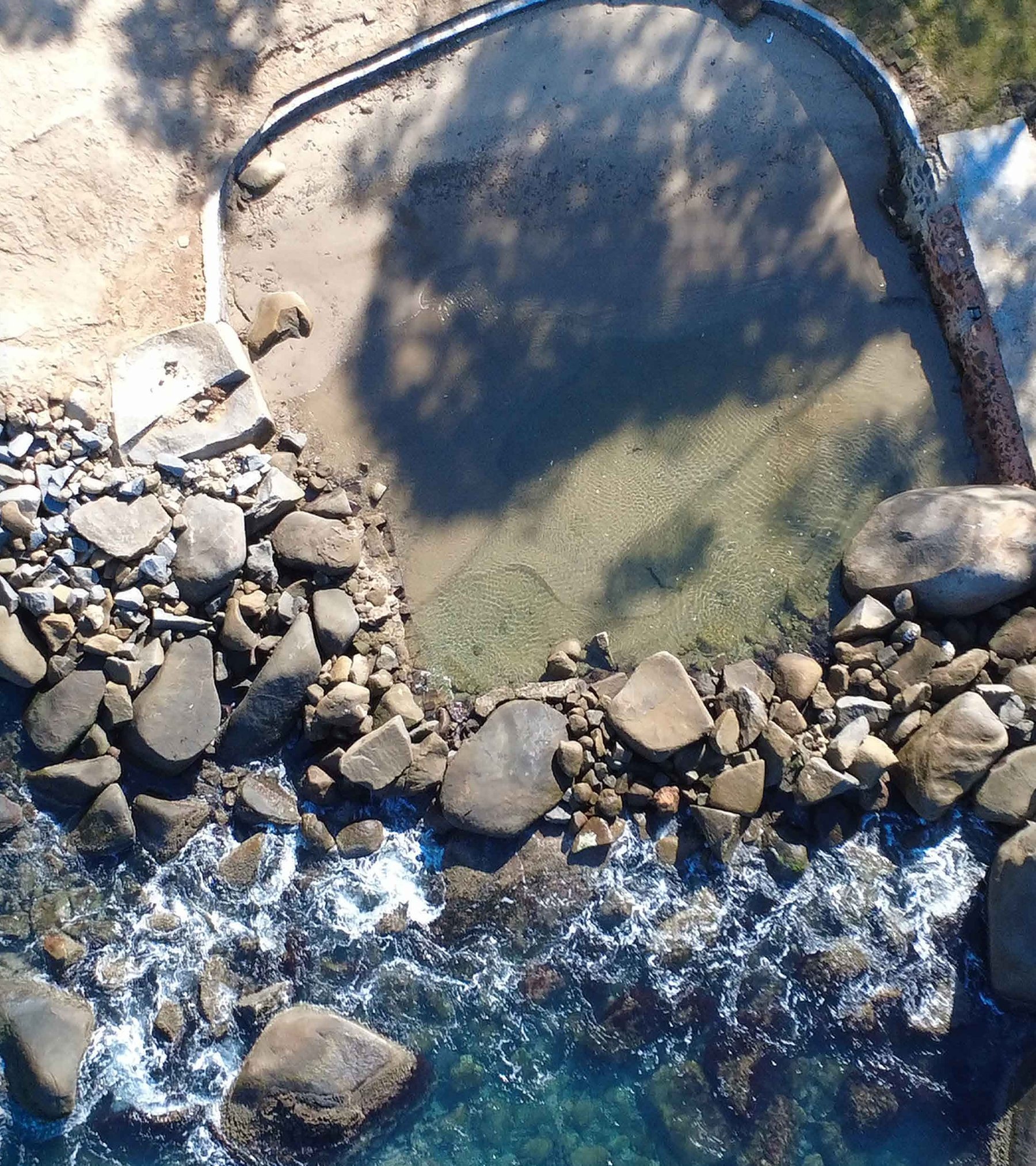 Piscina natural formada entre as pedras à beira-mar do condomínio.