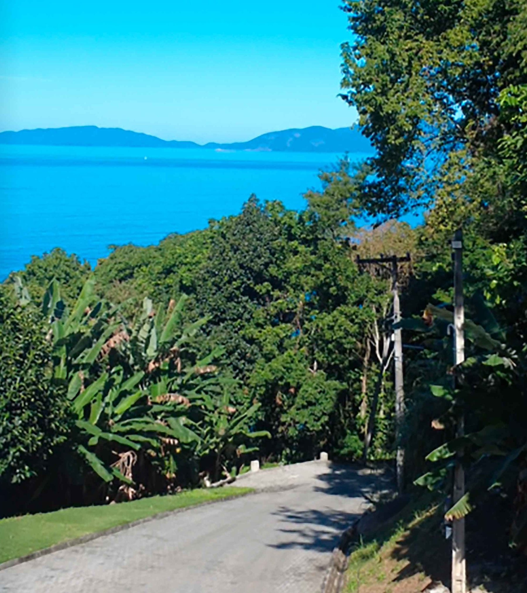 Estrada interna do condomínio com vista para o mar e a Ilha Grande.